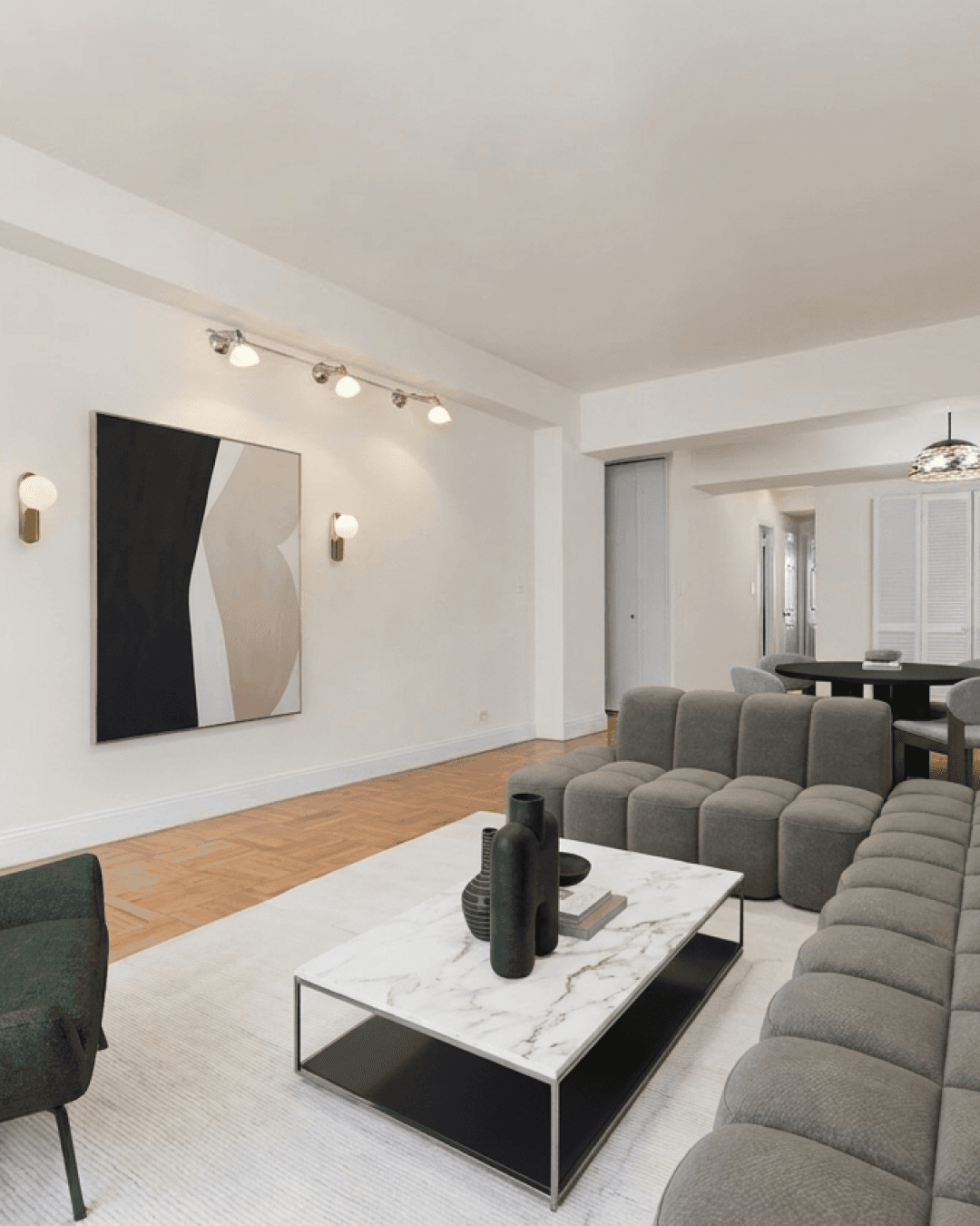 The same living room empty, then staged in AR — grey modular sofa, marble coffee table, art