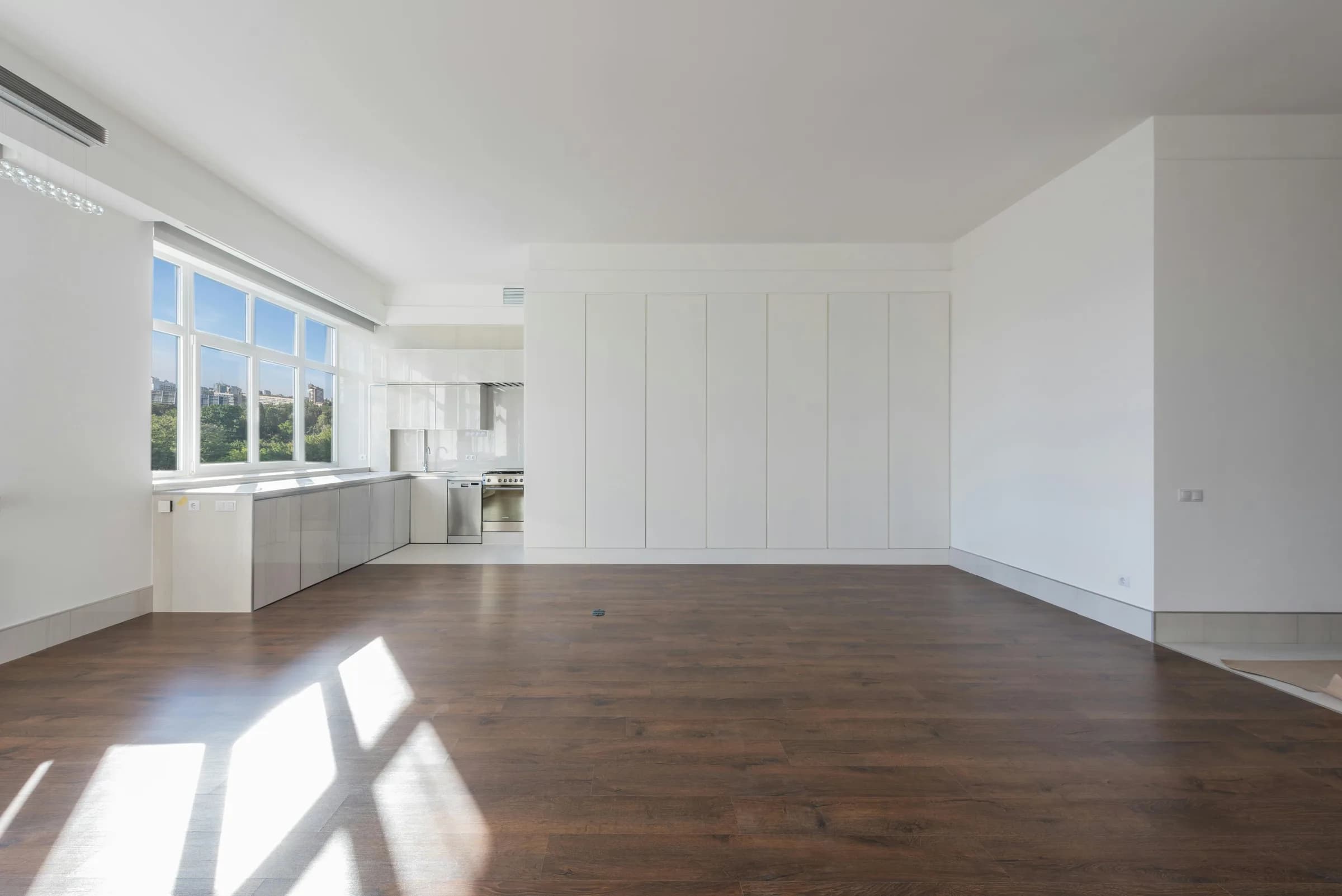 Empty apartment interior with hardwood floors and natural light
